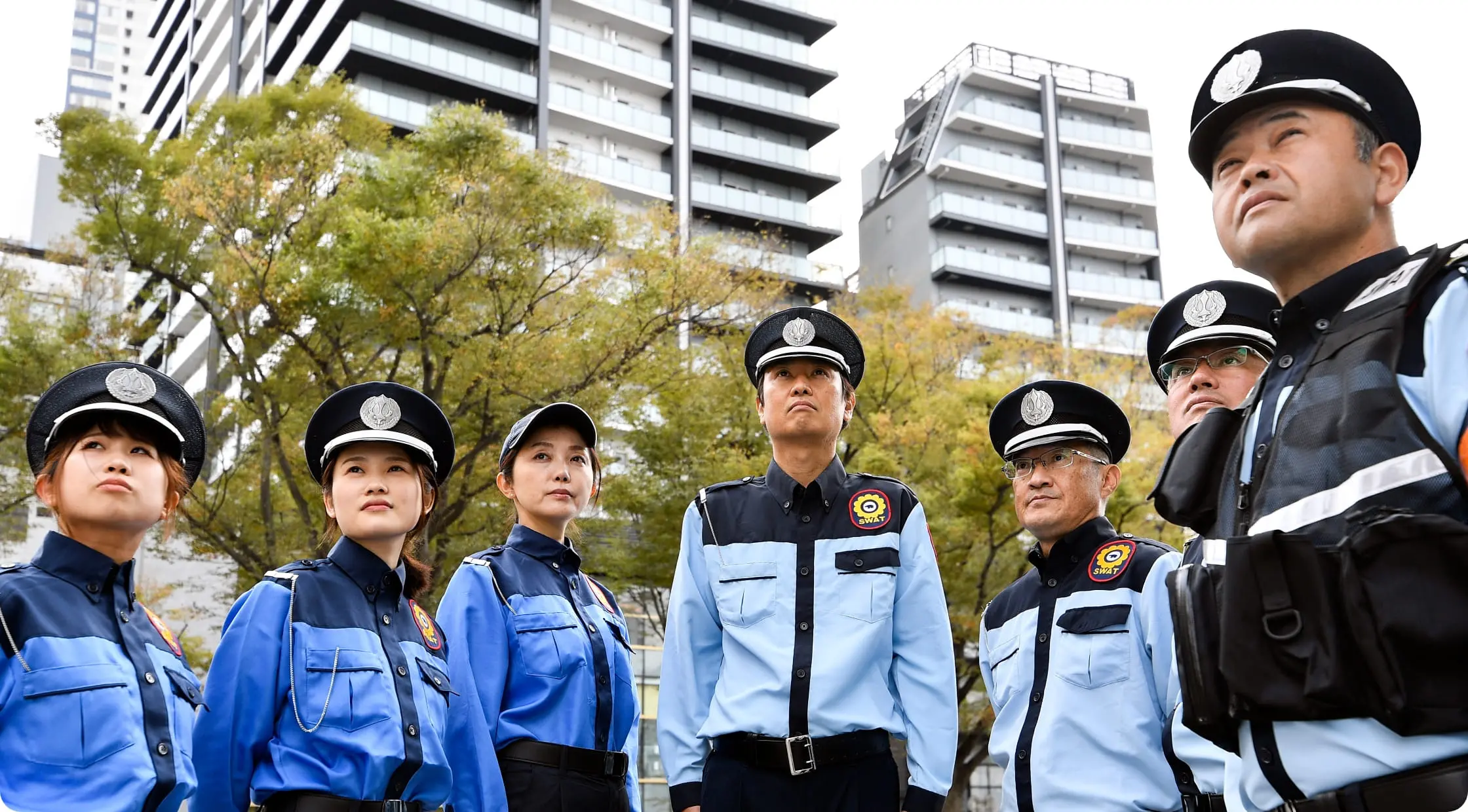 警備員たちがビルの前に整列している様子